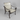 A patio armchair with a dark brown metal frame and woven cream-colored straps, shown on a light gray wood-look floor.