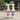 Two white spray bottles of Feron Clean and Feron Gard outdoor furniture care products standing on a stone patio with blurred patio chairs and greenery in the background.